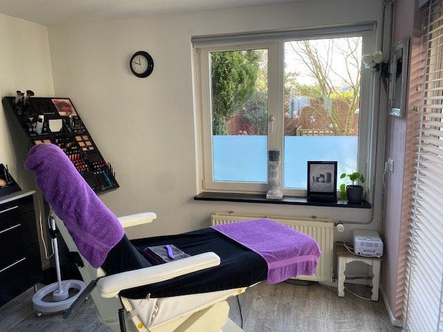 De behandelkamer van Beauté Bianca met behandelstoel, make-updisplay en uitzicht op de tuin